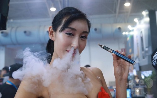 美女も豪快に鼻から「ふーっ」、中国・電子たばこ展示会