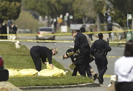 オイコス大学の銃撃事件で、遺体に覆いをかける警察官＝２日、オークランド（ＡＰ）