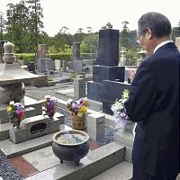 坂本弁護士一家の墓の前で手を合わせる岡田尚弁護士（３日午前、鎌倉市の円覚寺松嶺院で）
