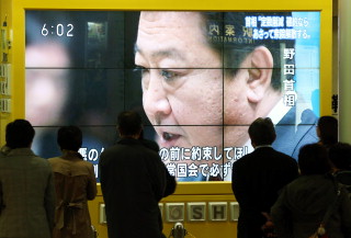 地下街の大型ビジョンに映されたテレビニュースで、野田首相が衆院の解散時期を発言する様子を見つめる市民ら＝札幌市中央区で２０１２年１１月１４日午後６時２分、貝塚太一撮影