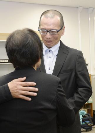 大分刑務所から釈放され、母親（手前）と再会する朴龍晧さん＝２６日夜、大阪市の司法記者クラブ