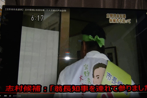 翁長氏と志村氏が個人住宅の扉を開けて志村氏が、「翁長知事を連れて参りました」と翁長知事を紹介する。