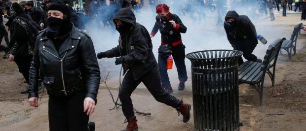 Activists race after being hit by a stun grenade while protesting against Trump on the sidelines of the inauguration. REUTERS/Adrees Latif