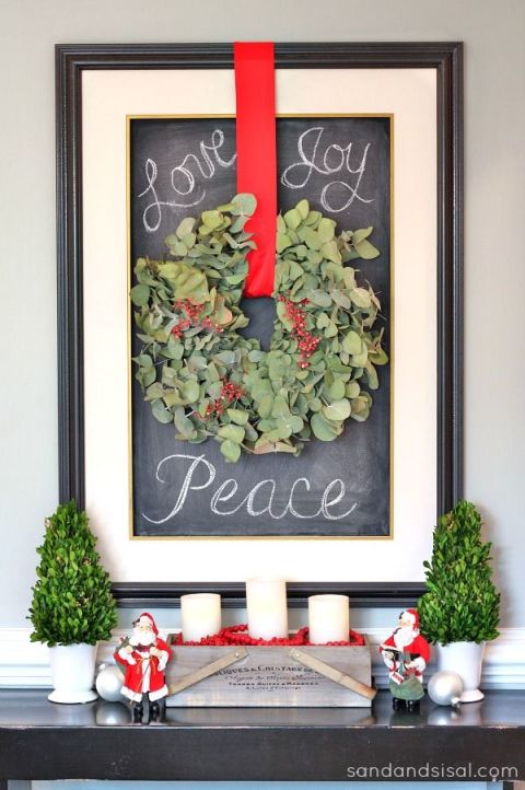 If your wreath is indoors, frame it. This blogger used a chalkboard to write warm and cheery messages beside it. 
Get the tutorial at Sand &amp; Sisal » 
