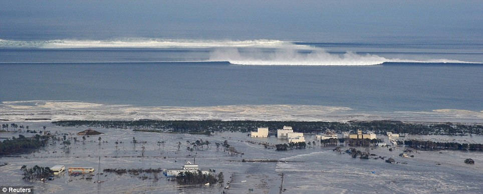 Horror: A huge wave is shown roaring in towards the coastal city of Natori in northwestern Japan
