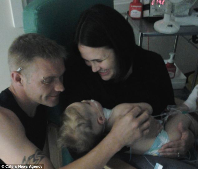 Relieved: Denise and Iain Page embrace their baby girl in hospital when doctors said she could go home