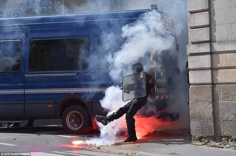 Young people have been at the forefront of the protest movement, with many young workers stuck on short-term contracts or internships while hoping to secure a permanent job. Pictured: A policeman kicks a flare stick thrown at him by protesters