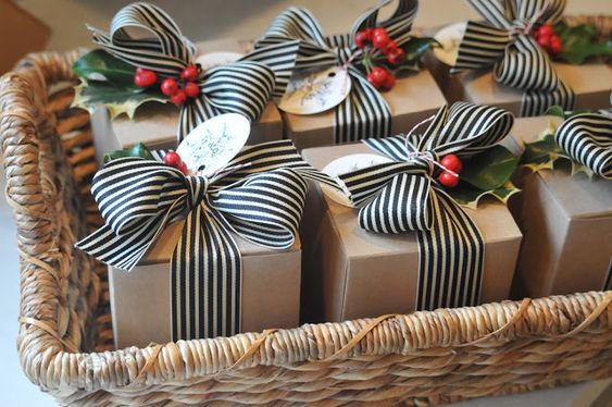 Homemade Christmas cookies in a craft box with food safe tissue paper, sheets of parchment paper between them, striped ribbon, and a tag with a couple of holly leaves. Recipe for Chocolate Peanut Butter Glob Cookies.