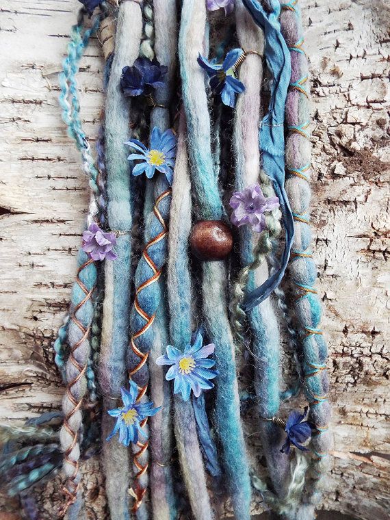 Hair wrap with friendship bracelet string, next to hair feathers