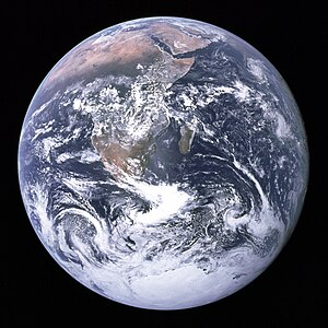 Original caption: "View of the Earth as seen by the Apollo 17 crew traveling toward the moon. This translunar coast photograph extends from the Mediterranean Sea area to the Antarctica south polar ice cap. This is the first time the Apollo trajectory made it possible to photograph the south polar ice cap. Note the heavy cloud cover in the Southern Hemisphere. Almost the entire coastline of Africa is clearly visible. The Arabian Peninsula can be seen at the northeastern edge of Africa. The large island off the coast of Africa is Madagascar. The Asian mainland is on the horizon toward the northeast."