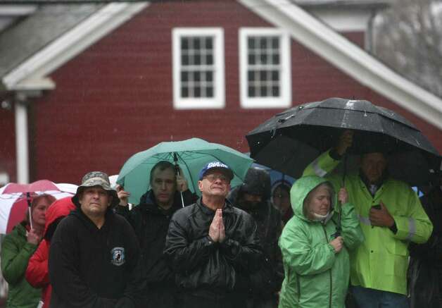 People, including Joe Saleem, center, observe a moment of silence led by Connecticut Governor Dannel Malloy, Lt. Governor Nancy Wyman and First Selectman Patricia Llodra in front of Edmond Town Hall in Newtown. The moment of silence and bell tolling was held across the state on Friday, December 21, 2012, the one week anniversary of the Sandy Hook shootings. Saleem said he lived in Newtown for 54 years but moved to North Carolina. But after the violence that took 28 people, Saleem returned to his hometown. 