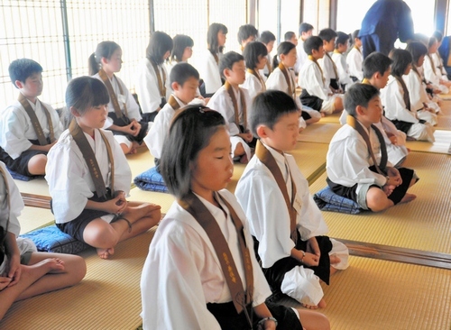 写真：暑い本堂で座禅を組む子どもたち＝新温泉町熊谷