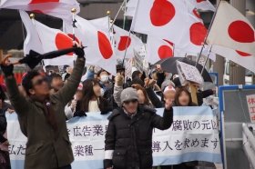 電通本社に向け、シュピレヒコールを上げるデモ隊