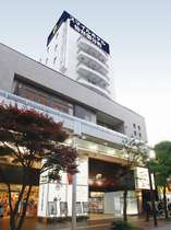 買物通り「一番町アーケード」内に位置。白の外壁、青と黄色の看板が目印