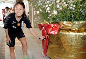 被災地に送るなでしこの花にサインする沢