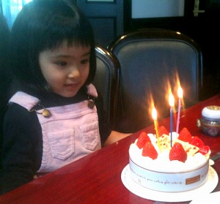 3歳の誕生日ケーキを前に